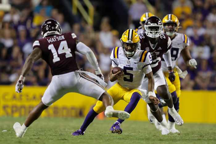 Sep 17, 2022; Baton Rouge, Louisiana, USA; LSU Tigers quarterback Jayden Daniels (5) scrambles against Mississippi State Bulldogs linebacker Nathaniel Watson (14) during the second half at Tiger Stadium. Mandatory Credit: Stephen Lew-USA TODAY Sports